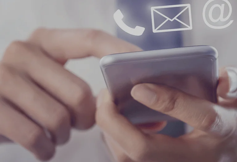 A hand gripping a mobile phone, showcasing multiple email icons on its screen.